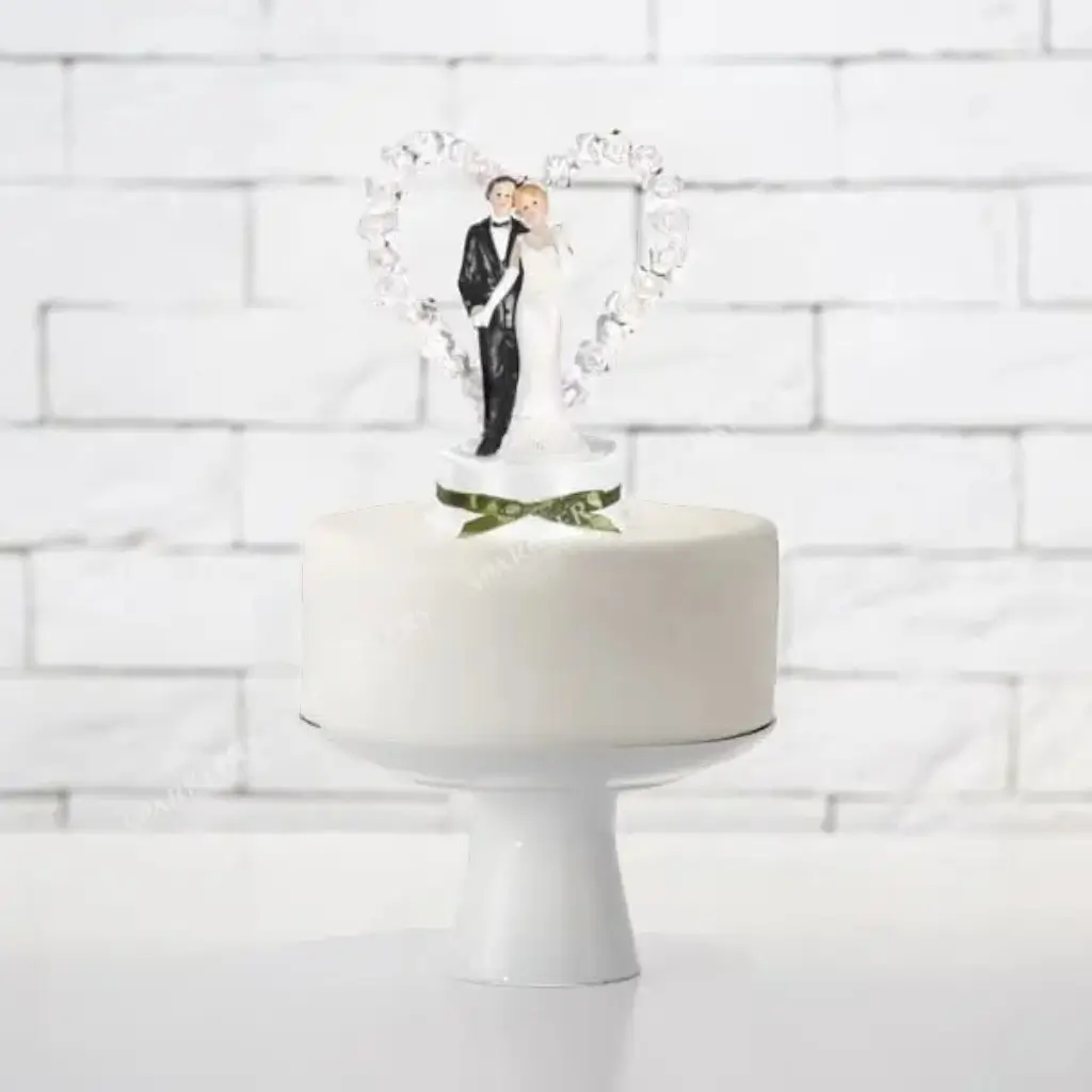 Figurina di matrimonio di coppia su cuore bianco 